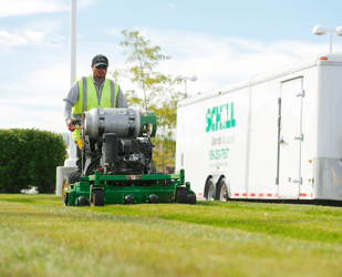 Schill Grounds Management commercial landscaping professional on riding mower 