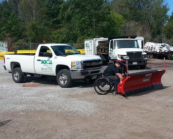 fleet coordinator Scott Scarvelli checking connections on the plow before mounting it to the truck