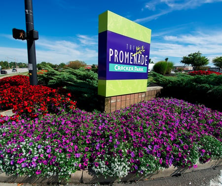 commercial landscaping in front of business sign, layered flowers