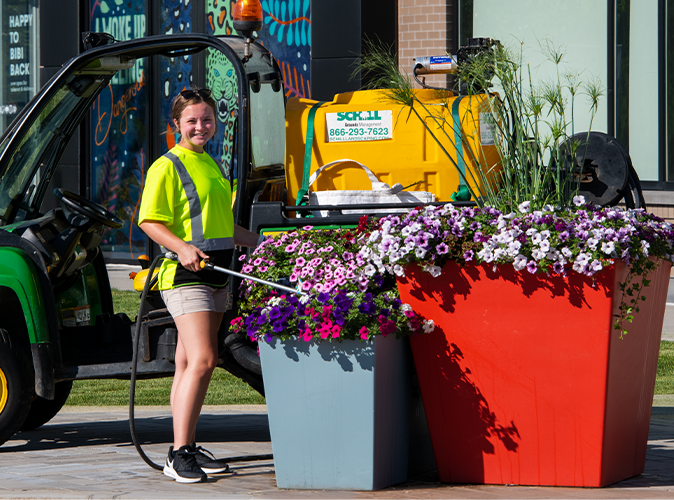 Schill landscaper watering plants at commercial property