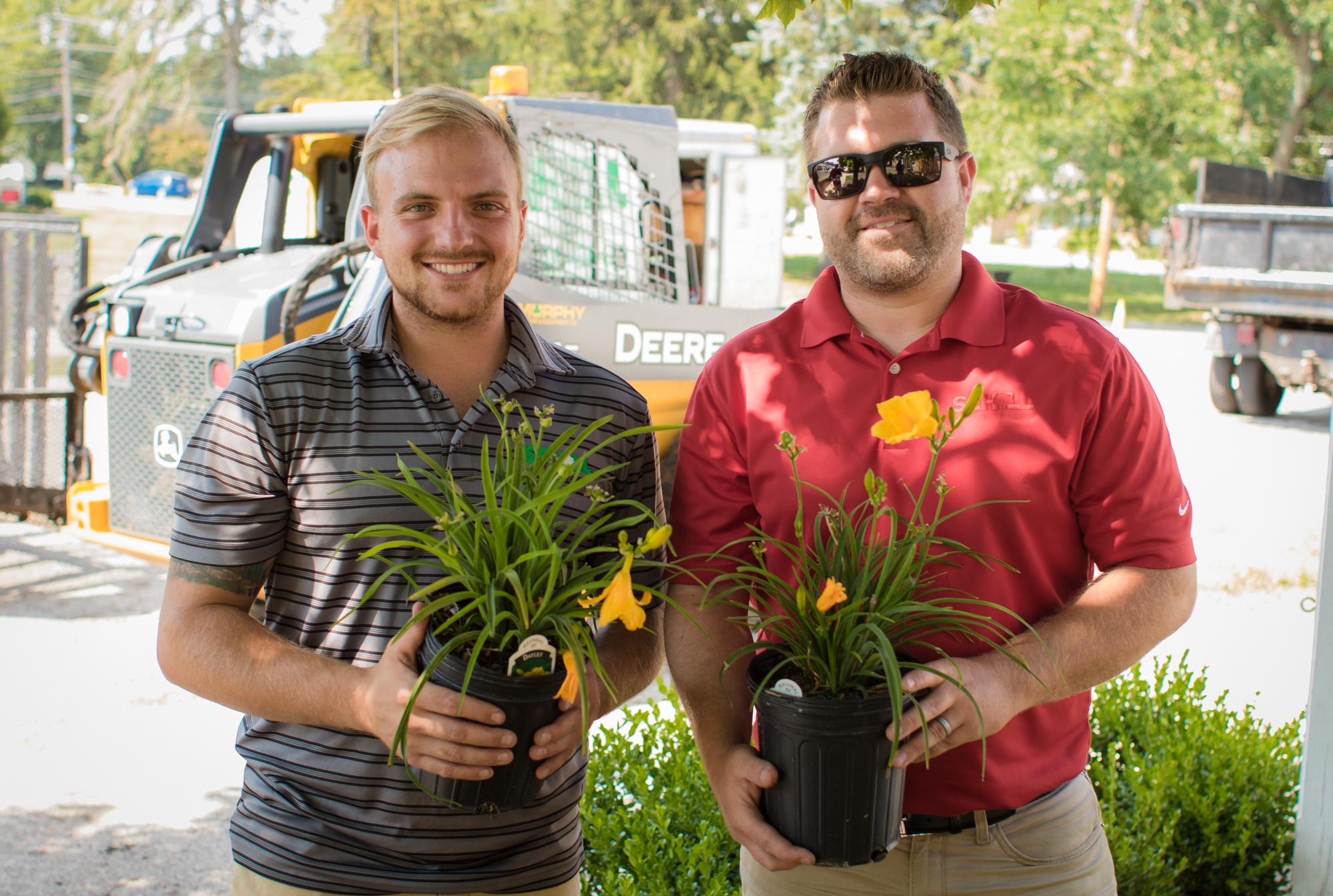 Schill landscapers holding flowers to be planted at commercial property of city hall